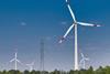 Wind turbines generating energy alongside power lines