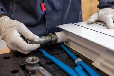 Plumber installing a radiator pipe