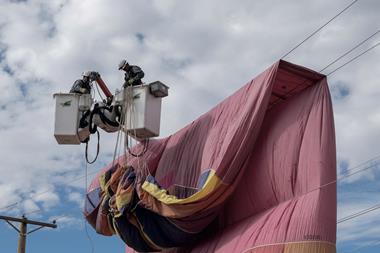 PNM workers remove a hot air balloon from power lines during a safety demonstration in Mexico