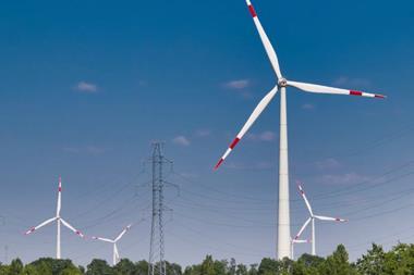Wind turbines generating energy alongside power lines