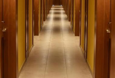 Turned-on lights along hotel hallway