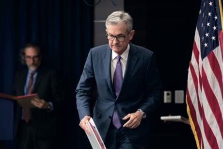 federal reserve chairman jerome powell approaches reporters having made the first interest rate cut in several years