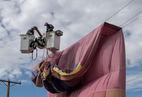 PNM workers remove a hot air balloon from power lines during a safety demonstration in Mexico