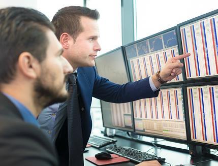 stock traders looking at screen rs
