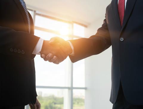 dealmakers handshake with sun coming through window rs
